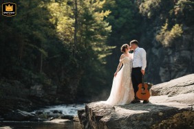 The couple share a quiet kiss beside the waterfall at Linville Falls, North Carolina, before hiking to their elopement ceremony